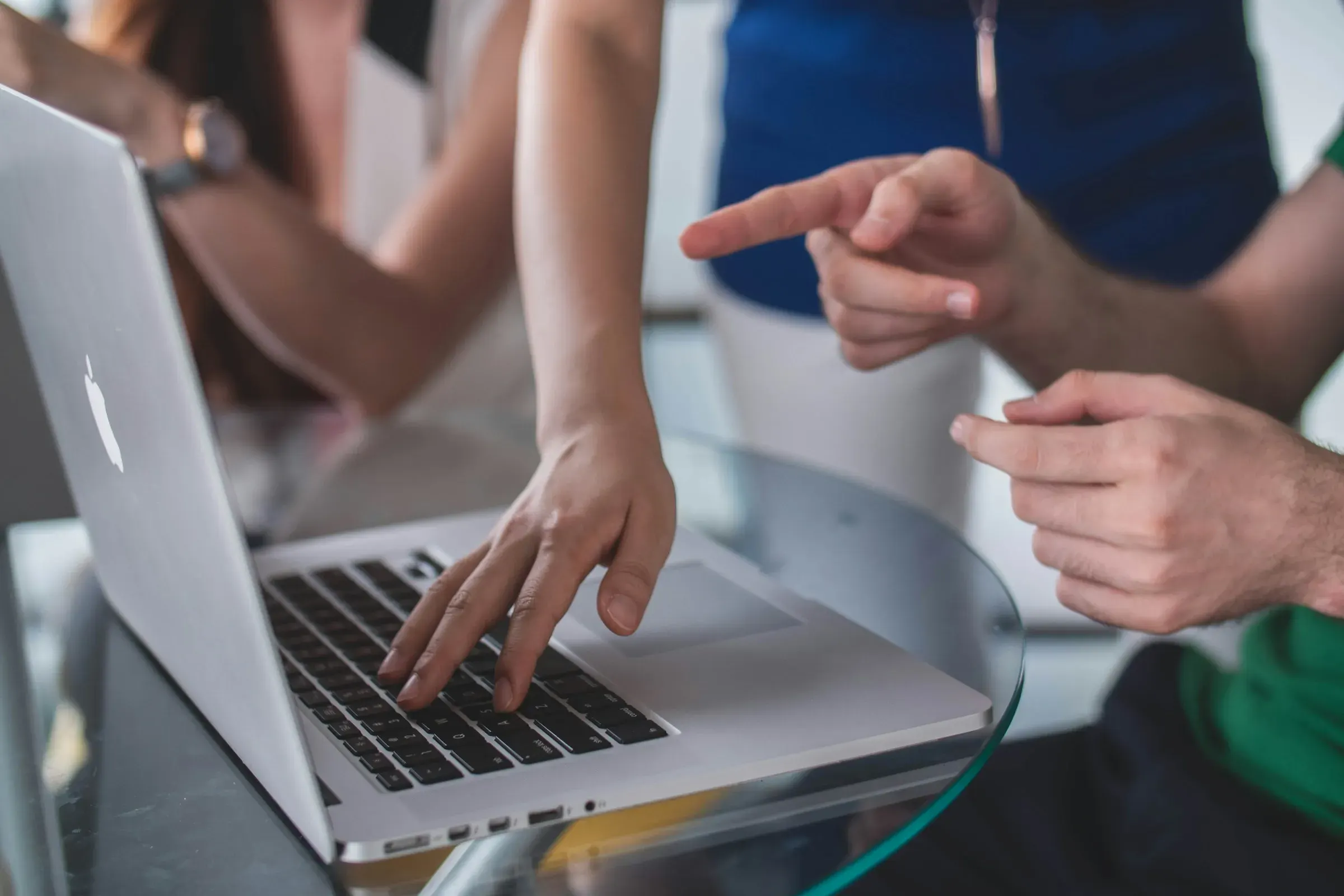 Handen van collega's die samen naar een laptop wijzen